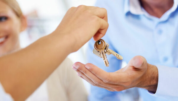 mortgage banker gives keys to homebuyer