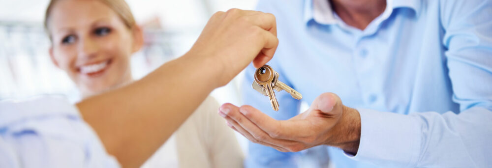 mortgage banker gives keys to homebuyer